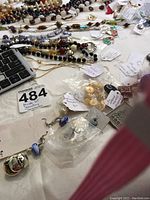 Overview of costume jewelry laid out, featuring various beaded necklaces, earrings, and some metal pieces next to a keyboard.