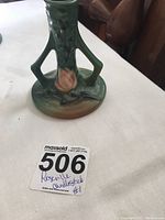 Photo of the green Roseville candlestick showing its base, floral pattern, and shape