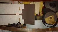 Photo showing various sandpaper sheets, rolled tape, and work gloves.