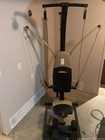Full front view of the Bowflex home gym with seat, backrest, cables and pulleys visible.