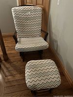 Front view of the glider chair and ottoman showing the chevron-pattern cushions and wood frame.
