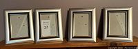Four silver and black 4x6 photo frames arranged side by side, front facing.