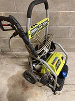 Front and side views of the RYOBI electric power washer showing the frame, hose, and handle details.