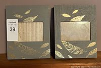 Two wooden picture frames side by side with 4x6 photo openings and gold feather decoration