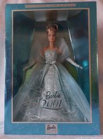 Photo showing full Barbie doll in original blue Collector's Edition box with visible 'Barbie 2001' marking on the front.