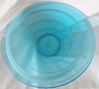 Top view of light cobalt blue glass bowl showing hypnotic swirl pattern and internal bubbles.