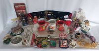 Photo shows the entire collection of Christmas themed items including plates, figurines, mugs, ornaments, and small holiday decorations.
