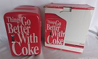 Mini red Coca Cola personal fridge and original box with visible wear on box.