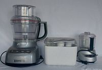 KitchenAid and Cuisinart food processors with accessory container showing lot contents