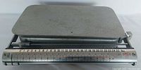 Top view of metal weighing platform and scale bar with weight range from 0 to 24 pounds, marked OMCO Letter Parcel Scale.