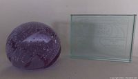 Purple art glass paperweight with bubbles, displayed alongside the rectangular 3 Flags Classic paperweight