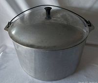 Full view of large heavy-duty cast aluminum pot with fitted lid and black knob topper