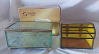 Both glass trinket boxes side by side with Gunther Mele box showing floral cut glass and gold plated rims, alongside yellow stained glass box.