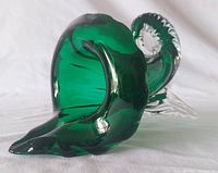 Photo showing the entire green glass piece from side angle highlighting the applied clear glass feet and organic curved shape.