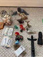 Wide view of the complete lot showing all animal figurines and items including the glass jar with shells and ceramic number tiles.