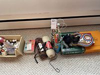Overview photo of assorted crafting supplies including yarn, knitting needles, board games, and additional crafting materials.