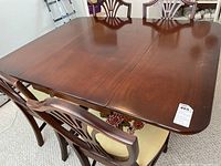 Photo of wooden dining table top with four chairs around it