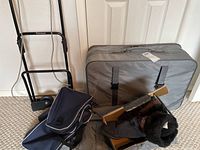 Full lot showing Samsonite suitcase, blue luggage bag, rolling cart, and black ladies boots in box.