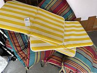 Yellow and white striped cushions stacked on top of multicolor striped cushions to show colors and count.