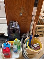 Overall lot view showing vacuum, buckets, hoses and cleaning supplies