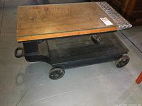 Side view showing full cast iron base with wheels and wood top