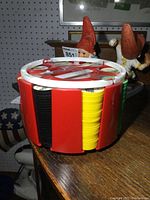 Side view of the circular red plastic coin carrier showing coin colors and sections