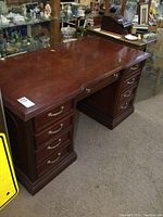 Front side view of the cherry finish office desk showing 7 drawers and smooth working surface