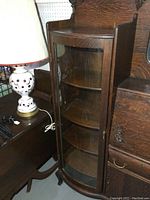 Left curved glass door opens to reveal four curved glass shelves within solid oak curio section