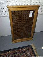 Straight view of solid oak framed display case with multiple grid compartments and a hinged front door