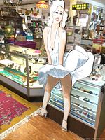 Front full view of the life-size painted wooden Marilyn Monroe figure in white dress.