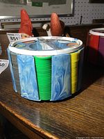 Side view of plastic carrier showing stacks of green, yellow, gray, and blue plastic airplane coins.