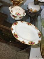 Image showing the covered bakeware dish with lid and a serving platter with floral rose pattern and gold trims.
