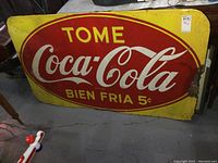 Full view of rectangular sign showing yellow background with red oval and white Coca-Cola logo