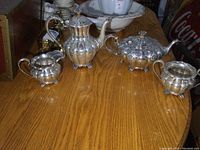 Photo showing the complete set with all four pieces on a wooden table, displaying shape and design details