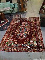 Full view of the vintage floral patterned area rug laid flat on floor, showing overall design and colors.