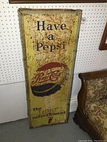 Full front view of sign leaning against pegboard and sofa