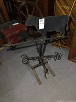 Overall view of cow silhouette weather vane on decorative hook base