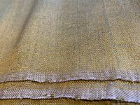 Close-up of folded fabric edge showing selvage and metallic silk weave