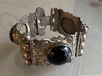 Side angled view showing the chunky design, silver spheres, black onyx stones, and detailed clasp.