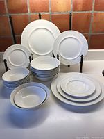 Group shot of all plates and bowls arranged on countertop against tiled background
