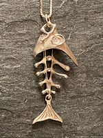 Full view of the articulating fish pendant hanging on the box chain necklace. Shows overall pendant design and size.