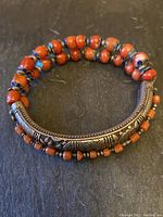 Full bracelet laid flat on dark surface showing overall design and bead strands