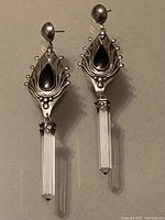 Pair of sterling silver earrings with black onyx stones and long hexagonal crystal drops.