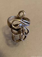 Front view of vintage sterling silver ring showing detailed leafy swirling pattern around the band.