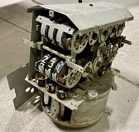 Front angle showing mechanical gears and numbered dials for measuring gasoline sales and gallons.