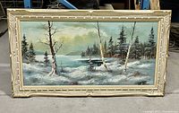 Front view of the framed winter landscape oil painting showing snow, trees, water, and sky.