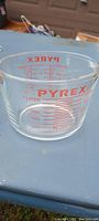 Close-up of the clear glass Pyrex measuring cup showing red measurement markings up to 1 liter.