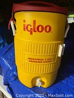 Full front view of yellow Igloo water cooler with red lid, showing branding and spigot details.