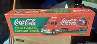 Photo of the original box showing Coca-Cola branding with '1998 Holiday Caravan Truck' text and festive graphics.