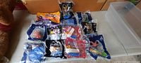 Photo showing 12 unopened McDonald's toy packages of various characters and themes, all sealed in original plastic bags.